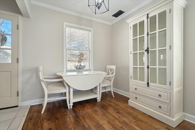 dining area featuring baseboards, a notable chandelier, wood finished floors, and crown molding