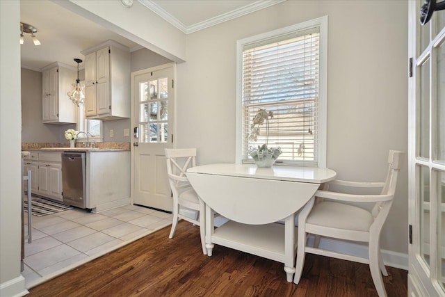 dining room featuring light wood-style floors, baseboards, and ornamental molding