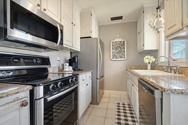 kitchen with ornamental molding, a sink, white cabinetry, stainless steel appliances, and light tile patterned floors