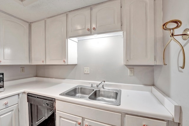 kitchen featuring dishwasher, white cabinetry, and a sink