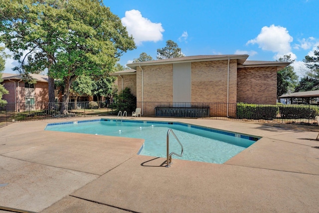 community pool featuring a patio and fence