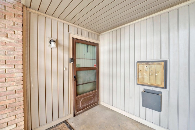 doorway to property featuring brick siding and board and batten siding