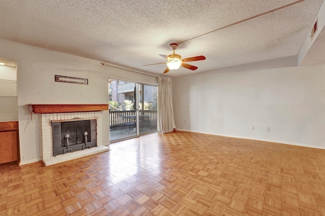 unfurnished living room featuring baseboards, a brick fireplace, a textured ceiling, and ceiling fan