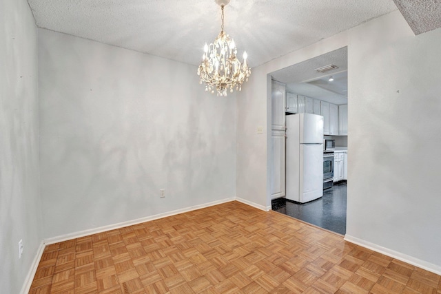 unfurnished room with a textured ceiling, visible vents, baseboards, and a chandelier