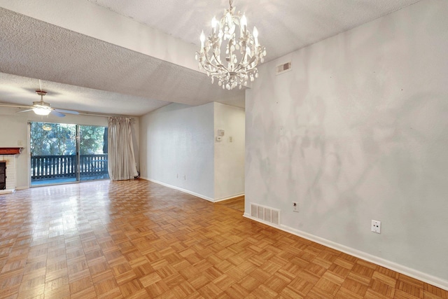 unfurnished living room featuring visible vents, ceiling fan with notable chandelier, a textured ceiling, and baseboards