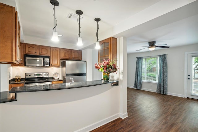 kitchen with dark wood-style floors, brown cabinets, and stainless steel appliances