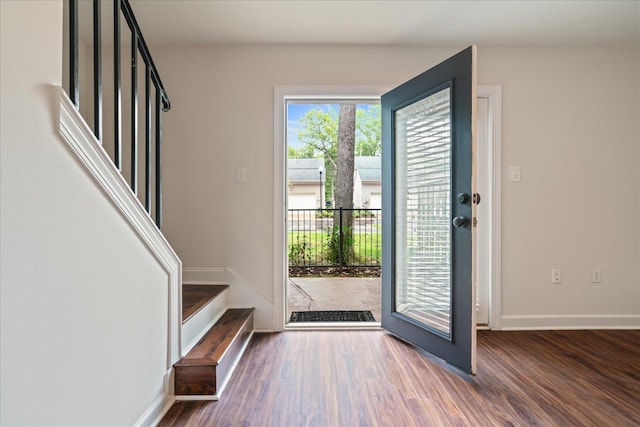 entryway with stairway, baseboards, and wood finished floors