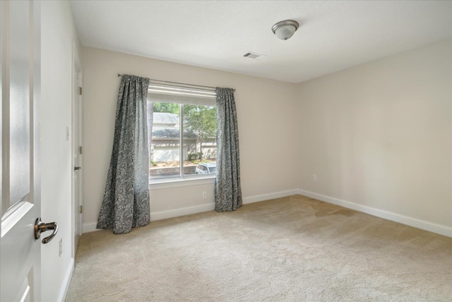 unfurnished room with visible vents, baseboards, and carpet floors