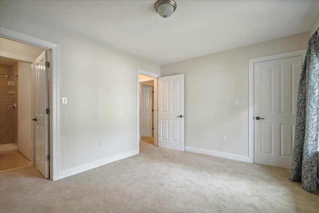 unfurnished bedroom with baseboards, carpet floors, and a textured ceiling