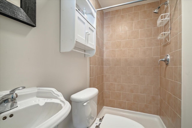 bathroom featuring a shower stall, toilet, and a sink