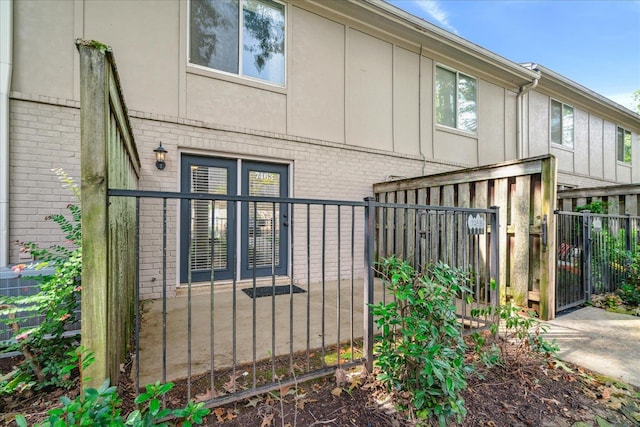 view of home's exterior featuring brick siding, board and batten siding, a gate, and fence