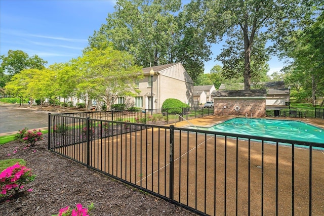 pool with a patio and fence