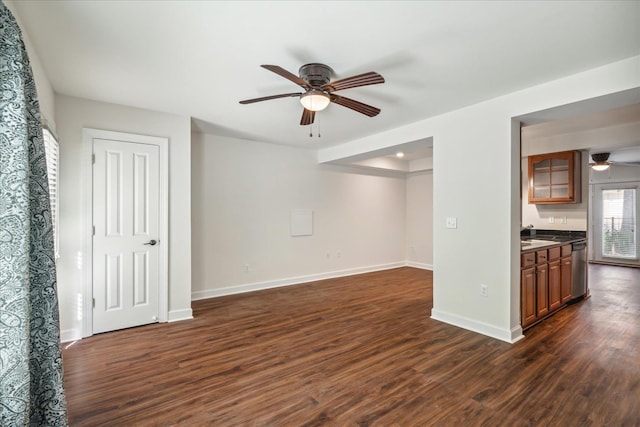 unfurnished living room featuring baseboards, dark wood-type flooring, and a ceiling fan