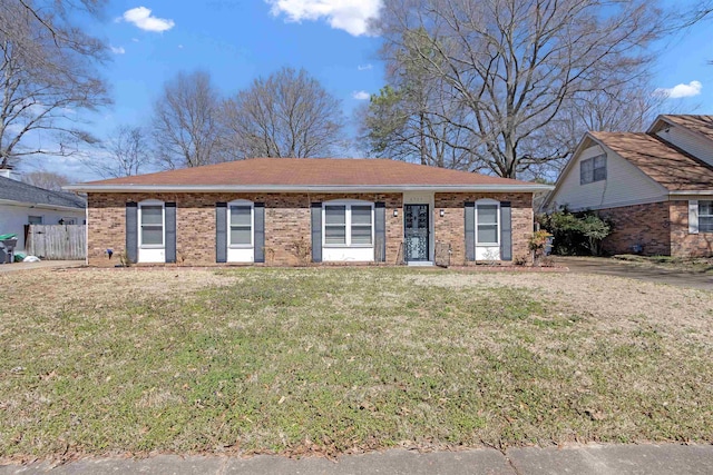 ranch-style home with brick siding, a front yard, and fence