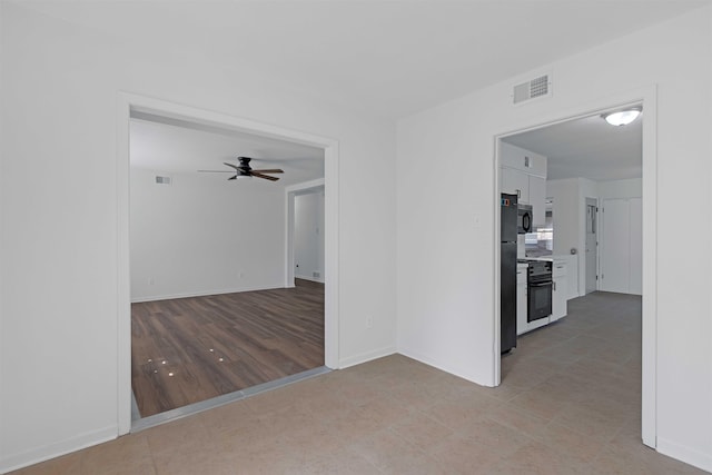 empty room featuring visible vents, baseboards, and a ceiling fan