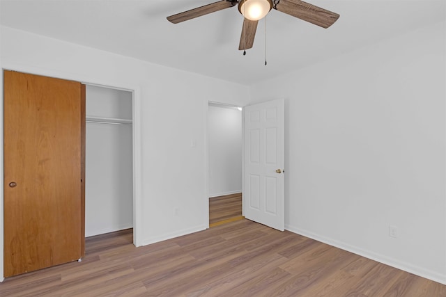 unfurnished bedroom featuring a ceiling fan, wood finished floors, a closet, and baseboards