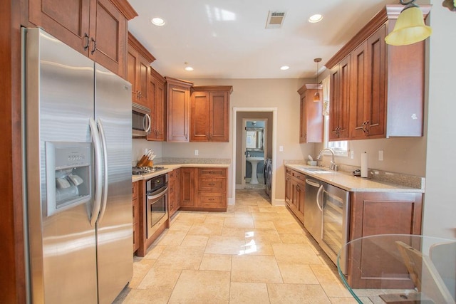 kitchen featuring visible vents, recessed lighting, a sink, stainless steel appliances, and brown cabinets