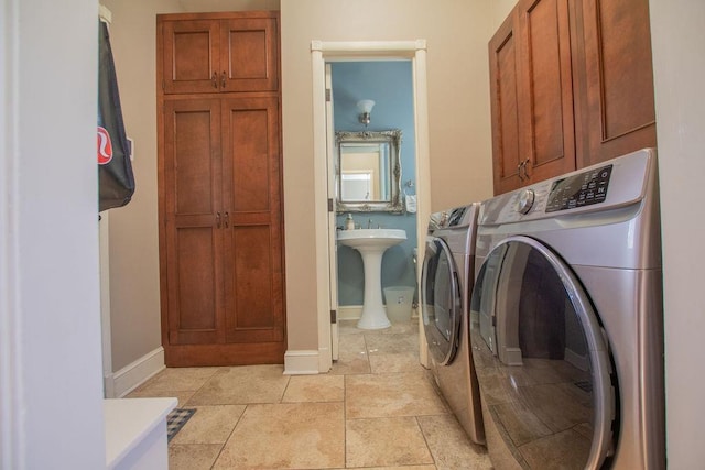 laundry room with cabinet space, separate washer and dryer, and baseboards