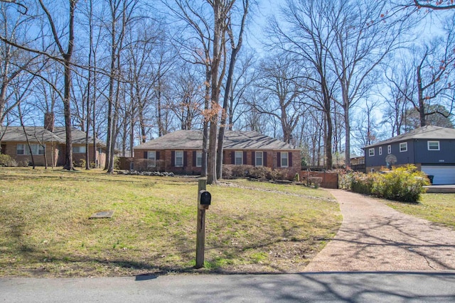 ranch-style home featuring a front lawn and brick siding