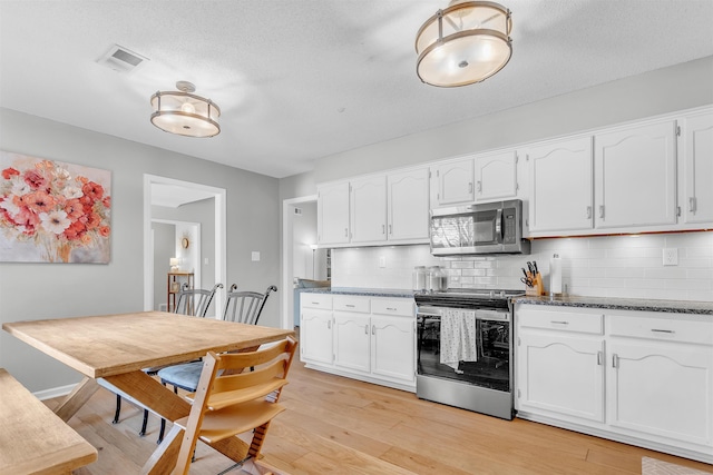 kitchen with visible vents, white cabinets, and stainless steel appliances