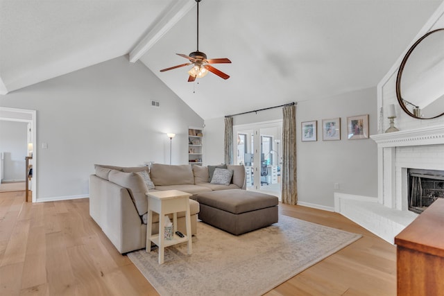 living room featuring visible vents, light wood finished floors, beam ceiling, ceiling fan, and french doors