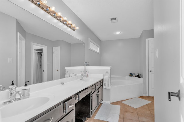 full bathroom featuring visible vents, double vanity, a sink, tile patterned floors, and a bath