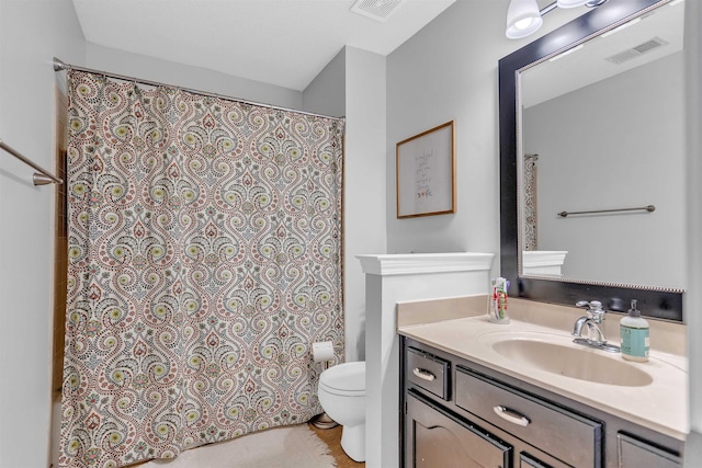 bathroom with vanity, toilet, a shower with curtain, and visible vents