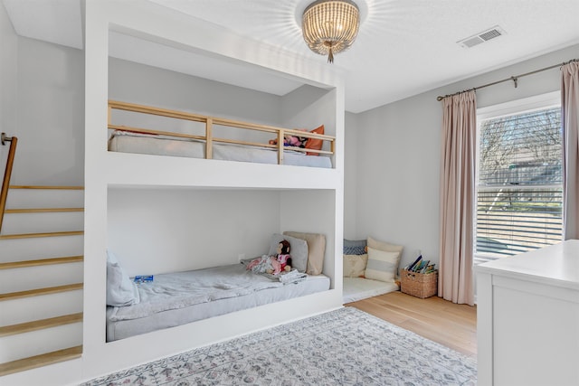 bedroom featuring visible vents and wood finished floors