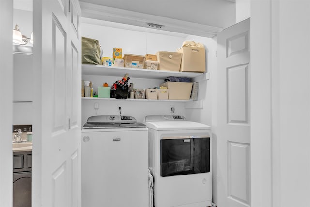 laundry area with laundry area, washer and dryer, and a sink