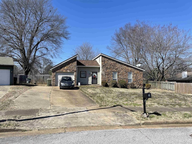 mid-century inspired home with stone siding, an attached garage, concrete driveway, and fence