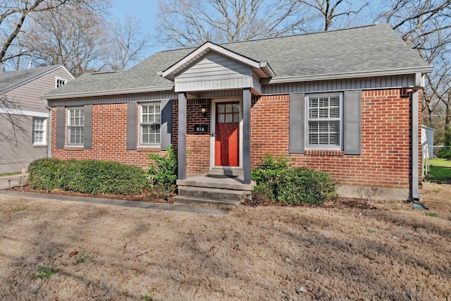 bungalow-style home featuring brick siding and a shingled roof