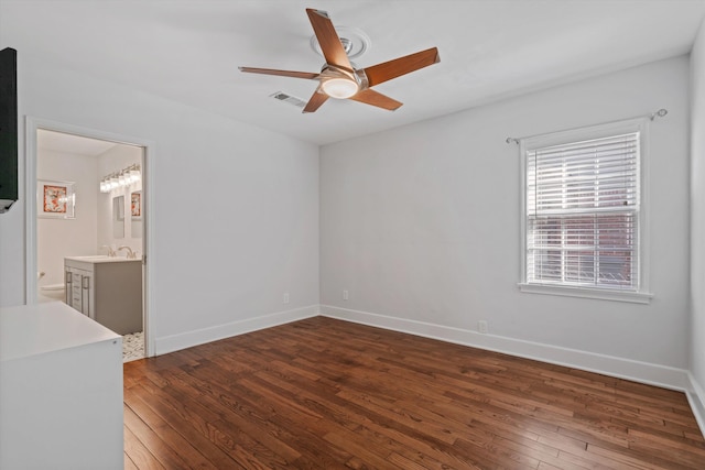 unfurnished room with a sink, baseboards, a ceiling fan, and hardwood / wood-style flooring