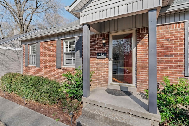 property entrance with brick siding and board and batten siding