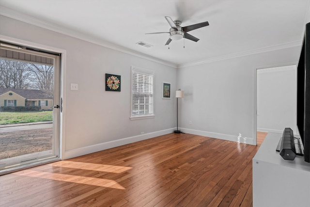 interior space featuring visible vents, crown molding, baseboards, ceiling fan, and hardwood / wood-style floors