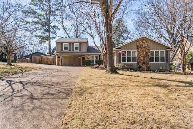 view of front facade with an attached carport, driveway, a front lawn, and fence