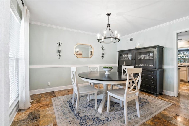 dining space featuring stone tile floors, a chandelier, baseboards, and ornamental molding