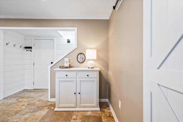 interior space with stone finish floor, baseboards, and ornamental molding