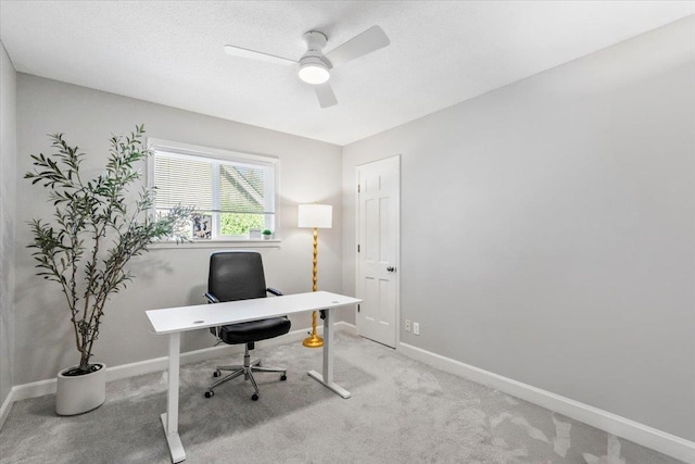 office featuring a textured ceiling, baseboards, carpet, and a ceiling fan