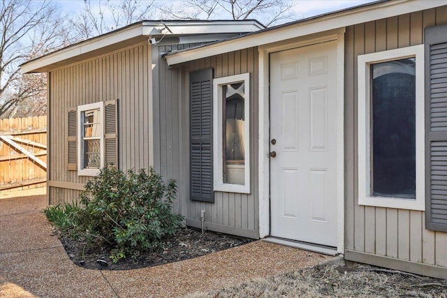 doorway to property featuring fence