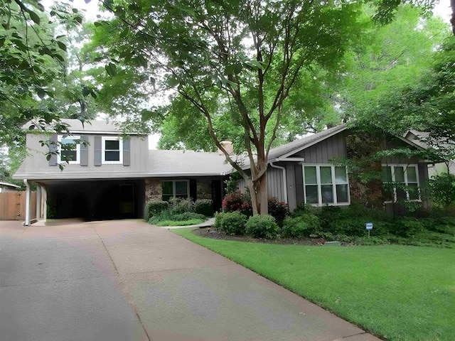 view of front of property featuring a garage, a chimney, concrete driveway, and a front lawn