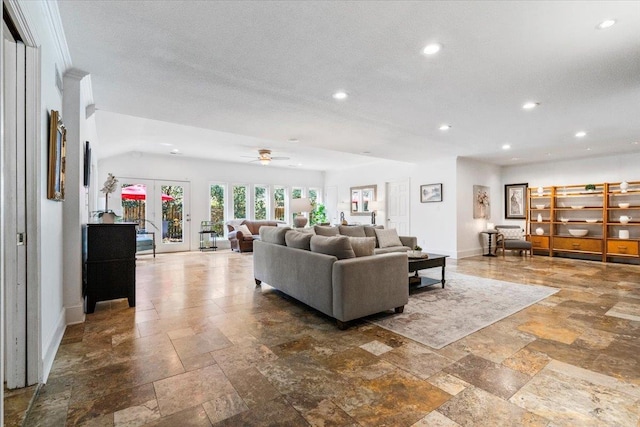 living area featuring a textured ceiling, recessed lighting, baseboards, and stone tile flooring