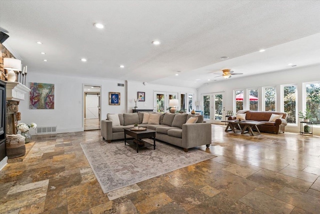 living area featuring recessed lighting, a fireplace, visible vents, and stone tile flooring