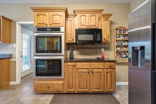 kitchen featuring tasteful backsplash, light tile patterned floors, black appliances, and baseboards