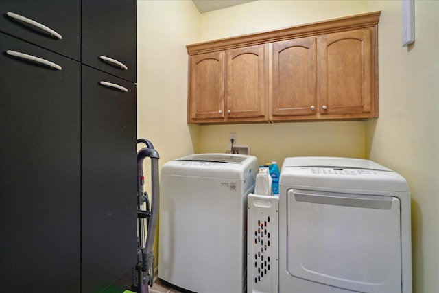 clothes washing area with cabinet space and independent washer and dryer