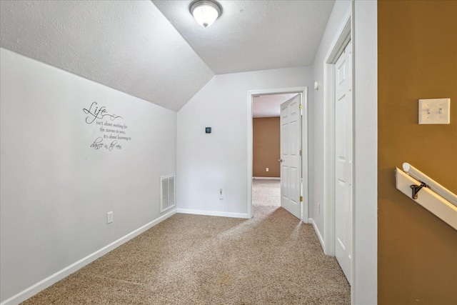 bonus room featuring visible vents, baseboards, vaulted ceiling, carpet flooring, and a textured ceiling