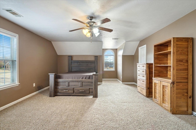 carpeted bedroom featuring visible vents, baseboards, ceiling fan, and vaulted ceiling