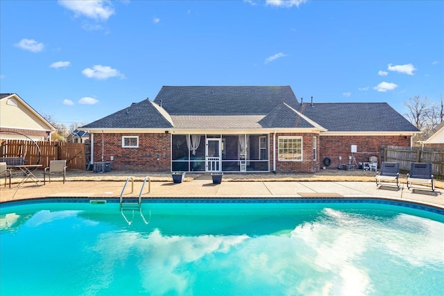 view of swimming pool with a fenced in pool, fence, a patio, and a sunroom