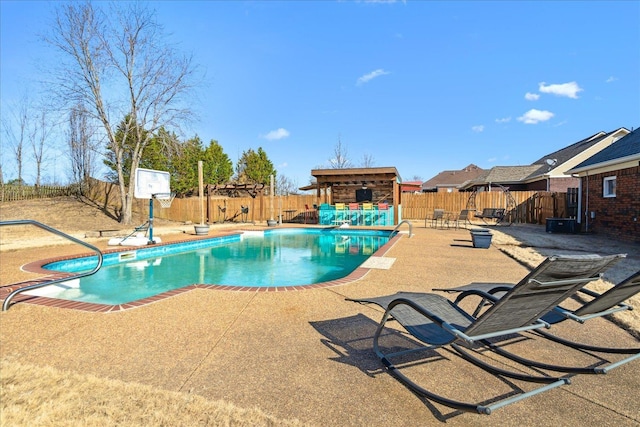 view of pool featuring a fenced in pool, a fenced backyard, a fireplace, and a patio area