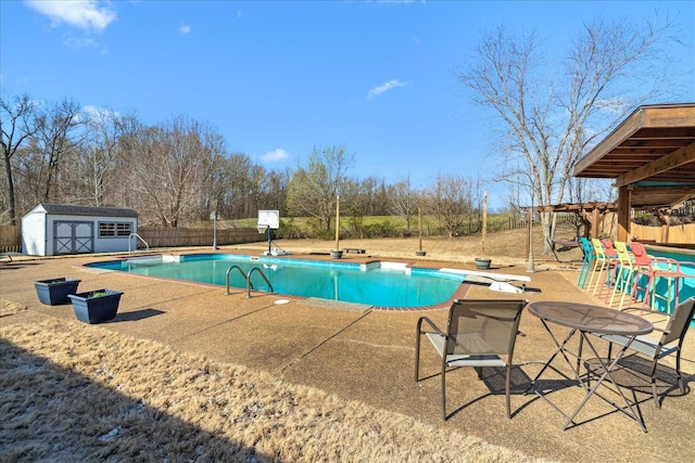 view of swimming pool with a patio area, a shed, a fenced in pool, and a diving board