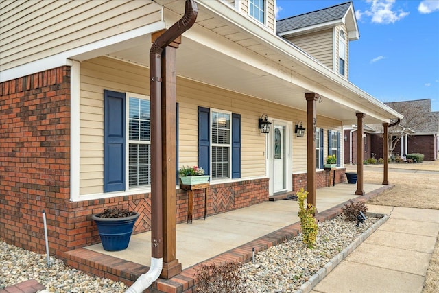 property entrance featuring brick siding and covered porch